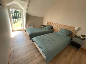 two beds in a room with a window at Gites La Ville Pain in Cancale