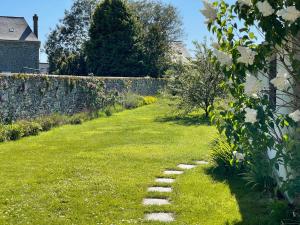 a garden with a stone path in the grass at Gites La Ville Pain in Cancale