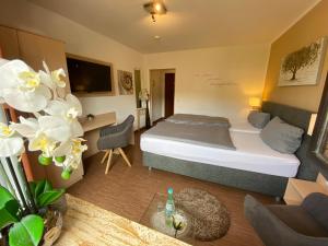 a hotel room with a bed and a desk at Landhotel Fasanenhof in Eschwege