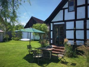 a table and chairs in front of a house at Fischerhaus Godewind 60 qm in Altwarp