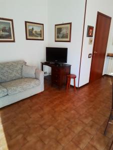 un soggiorno con divano e televisore di Casamarche a Montalto Dora
