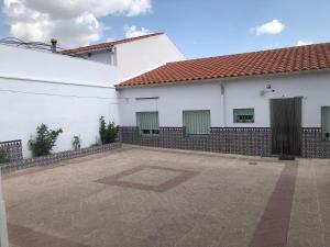 un edificio blanco con puertas verdes y un patio en El Cortijo en Villalgordo del Jucar