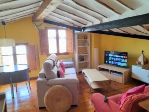 uma sala de estar com um sofá e uma televisão em Casasdetrevijano Cañon del rio leza em Soto en Cameros