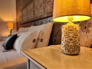 a lamp sitting on a table next to a bed at Villa Shepherd Lajares - LUXURY VILLA FUERTEVENTURA in Lajares