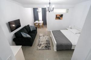 a bedroom with a bed and a couch and a table at Armada Aparthotel in Alba Iulia