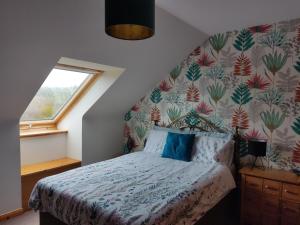 Auchleven的住宿－No ' 9 The Cooperage'，一间卧室配有一张带花卉壁纸的床
