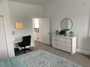a bedroom with a bed and a desk and a mirror at Stylish 2BD/1BA apartment located in Federal Hill in Baltimore