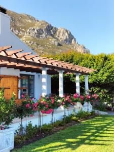 un jardín con flores y pérgola en Flatlet on Fifth en Hermanus