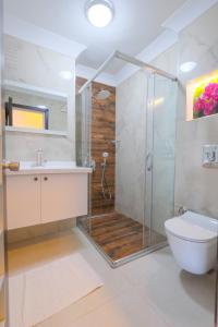 a bathroom with a shower and a toilet and a sink at Wien Star Hotel, Adults Only in Alanya