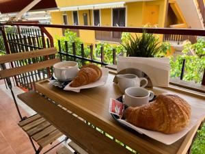 a table with two croissants and cups on a balcony at Oltremare rooms Agropoli in Agropoli