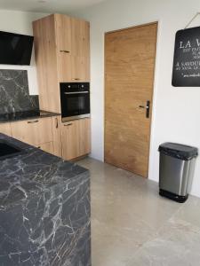 cocina con encimera y puerta de madera en Maison chaleureuse avec piscine et parking, en Saint-Gelais