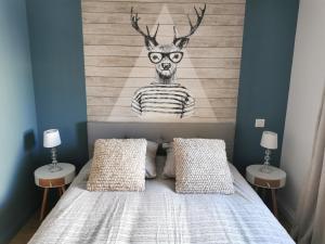 een slaapkamer met een bed met een schilderij van een hert bij Maison chaleureuse avec piscine et parking in Saint-Gelais
