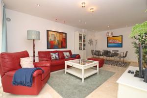 ein Wohnzimmer mit einem roten Sofa und einem Tisch in der Unterkunft Baía Residence I - Beach and Rest in São Martinho do Porto