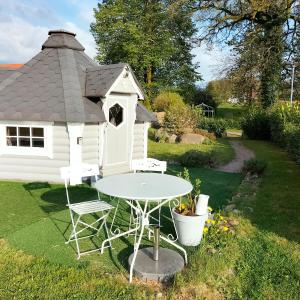 a table and chairs in front of a play house at Cabane des lutins - Belle Fleur in Saint-Nabord
