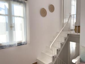 a white staircase in a white room with a window at Pepper Wind in Naousa