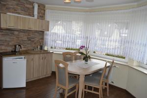 a kitchen with a table and chairs in a kitchen at Pokoje Gościnne Katarzyna Kur in Dębki