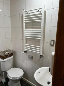 a white bathroom with a toilet and a sink at Casa Alojamiento in Punta Arenas