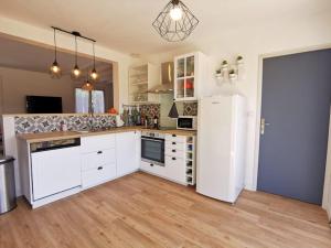 a kitchen with white cabinets and a white refrigerator at A CasA in Linxe