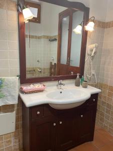 a bathroom with a sink and a large mirror at Aventina Holiday Home in Burcèi