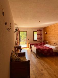una camera con due letti e un divano in camera di Hotel L'Artisin a Limone Piemonte