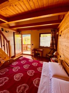 Habitación grande con alfombra roja grande en el suelo en Hotel L'Artisin, en Limone Piemonte