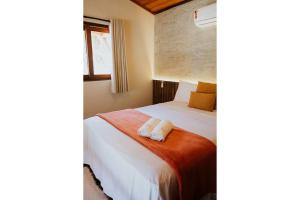 a bedroom with a bed with two towels on it at Vila do Porto, Praia do Patacho - Bangalô Milagres in Pôrto de Pedras +13 photos