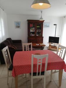 sala de estar con mesa, sillas y sofá en Maison bord de mer, en Penmarch