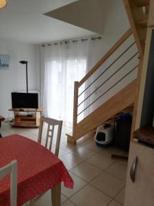 sala de estar con escalera, mesa y silla en Maison bord de mer, en Penmarch