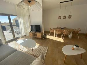 SUN BAY VILLAS APARTMENT في سان ميغيل ذي أبونا: غرفة معيشة مع أريكة وطاولة