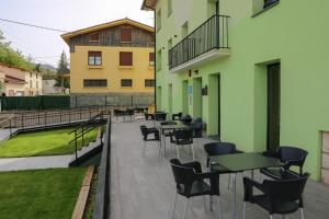 una fila di tavoli e sedie su un patio di ATERPE KANPEZU HOSTEL a Santa Cruz de Campezo