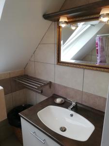 a bathroom with a sink and a mirror at Maison bord de mer in Penmarcʼh