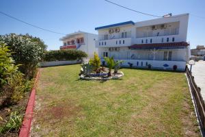 a large building with a yard in front of it at Villa Bel Passo Apartments in Kefalos