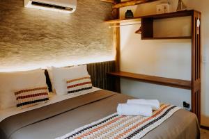 a bedroom with a bed with two towels on it at Vila do Porto, Praia do Patacho - Bangalô Patacho in Pôrto de Pedras