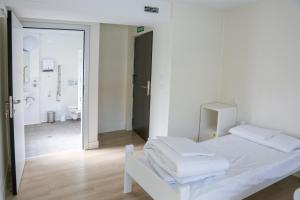 Habitación blanca con cama y baño. en ATERPE KANPEZU HOSTEL, en Santa Cruz de Campezo