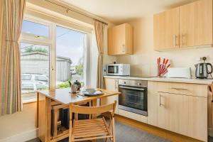 eine kleine Küche mit Tisch und Fenster in der Unterkunft Hillymouth in Ilfracombe
