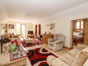 uma sala de estar com um sofá, cadeiras e uma mesa em Wold's View em Grainthorpe
