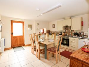 uma cozinha com uma mesa e cadeiras de madeira e uma mesa e uma mesa em Wold's View em Grainthorpe