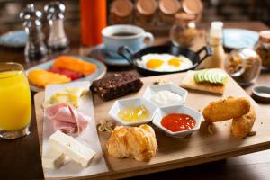 a wooden tray with breakfast foods on a table at Hotel Casa La Factoria by Faranda Boutique, a member of Radisson Individuals in Cartagena de Indias