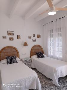 コニル・デ・ラ・フロンテーラにあるAlojamiento Rural "El Charco del Sultan"のベッドルーム1室(ベッド2台、窓付)