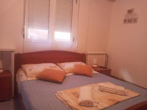 a bedroom with a bed with towels on it at Two in Petrovac na Moru