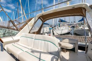 a boat with white seats on a dock with boats at yacht vedette Arlequin in Gruissan