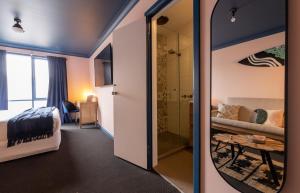 a room with a mirror and a bedroom at Roamer St Kilda - formerly Selina St Kilda Melbourne in Melbourne