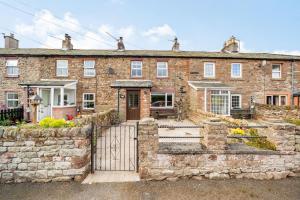 a brick house with a gate in front of it at Cross Fell View in Dufton