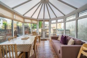 a conservatory with a table and a couch at Cross Fell View in Dufton