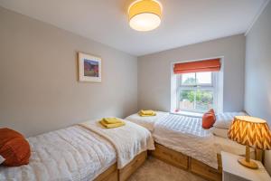 two beds in a bedroom with a window at Cross Fell View in Dufton