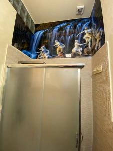 a bathroom with a waterfall mural above a shower door at Hollywood Inn Palermo in Palermo +37 photos