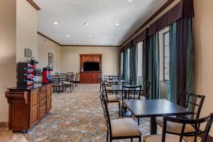 a dining room with tables and chairs and a television at Best Western Mineola Inn in Mineola