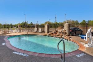 a swimming pool at a resort with chairs and a fence at Best Western Mineola Inn in Mineola