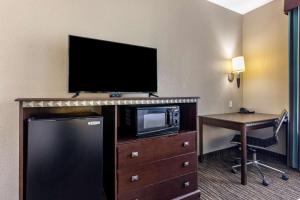 a hotel room with a television and a desk with a computer at Best Western Mineola Inn in Mineola