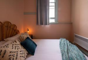 a bedroom with a bed with pillows and a window at Roamer St Kilda - formerly Selina St Kilda Melbourne in Melbourne